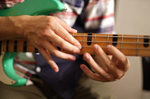 ベースギターでライトハンド奏法をする手元