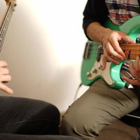 ライトハンド奏法で両手タッピングを弾き合うベーシストの写真