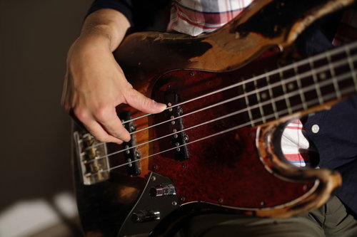 プロベーシストが指弾きする茶色いベースの右手