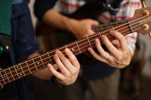 弦の押さえ方のお手本を見せるベース講師の左手