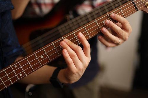 ベースの弦の押さえ方を手を添えて教えてもらう