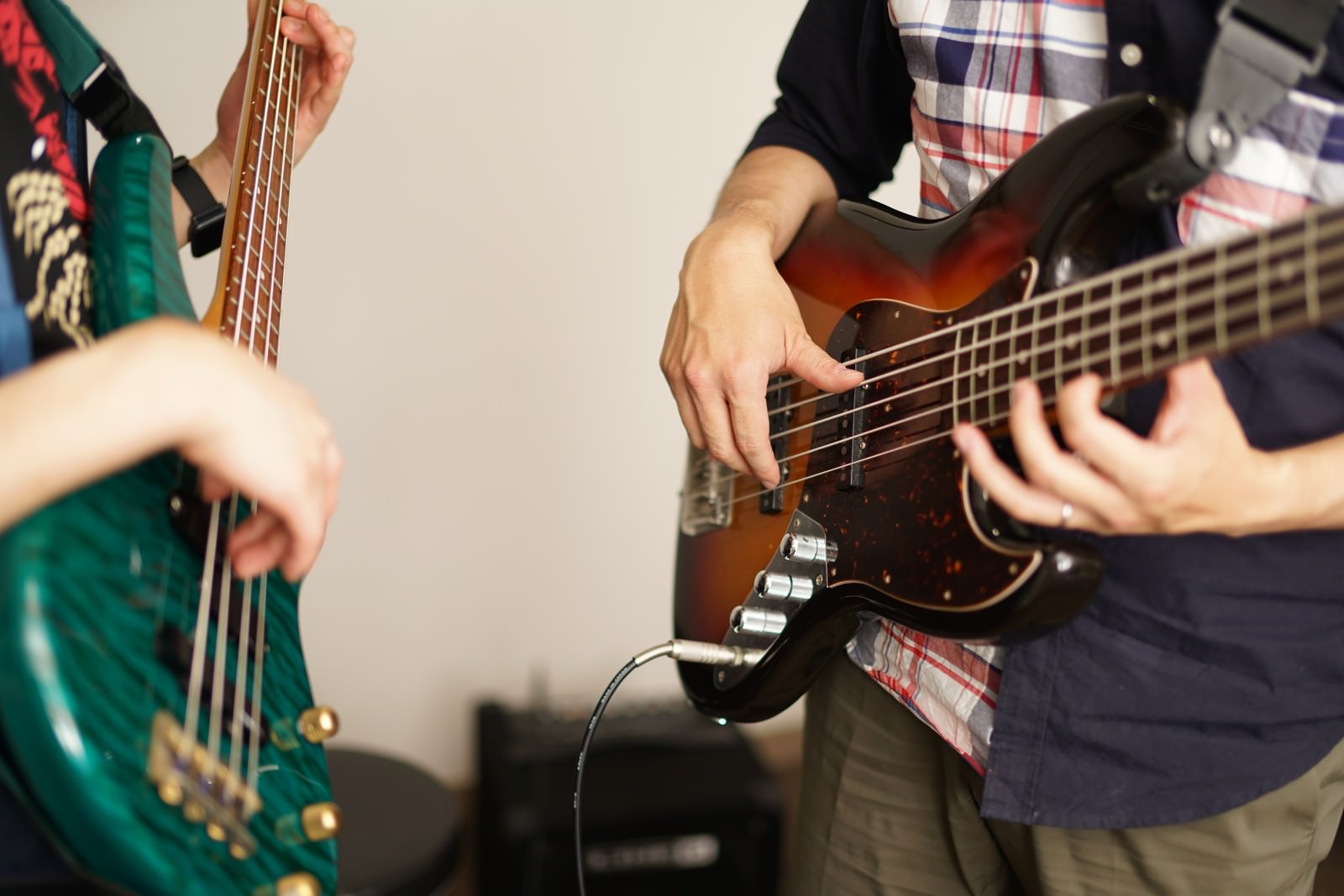 2人のミュージシャンがそれぞれエレキベースを持って演奏している様子