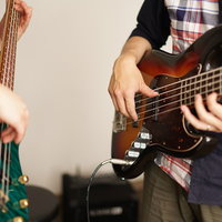 2人のベーシストがベースを弾く演奏シーンの写真