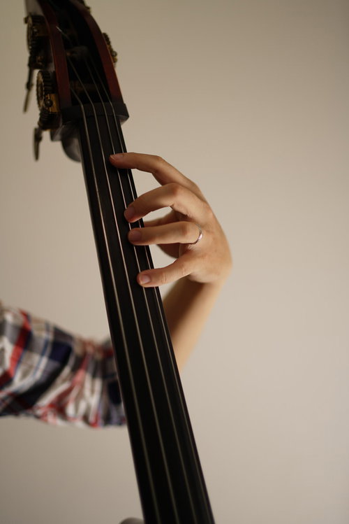 フレットレスのウッドベースを弾くベーシストの手元