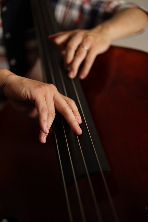 ウッドベースを弾く手元と弓の動き、弦を押さえる左手と弓を持つ右手