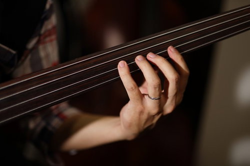 フレットレスベースを弾くベーシストの手元と指の動き