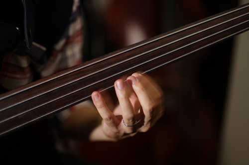 フレットレスベースを弾くベーシストの手元