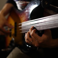 ベースギターを弾く男性ミュージシャンの写真