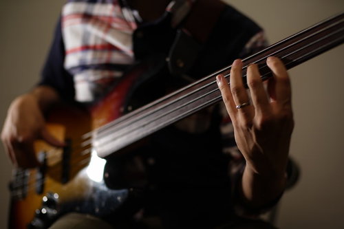 ベーシストの手元でベースを弾く演奏シーン