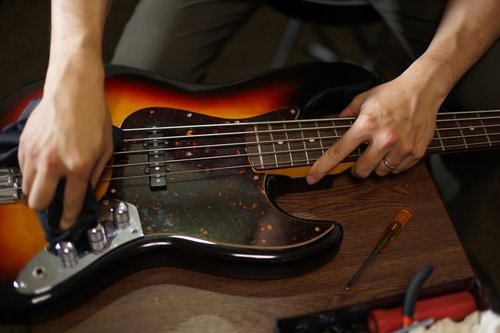 ベースギターを磨いてメンテナンス中のベーシスト