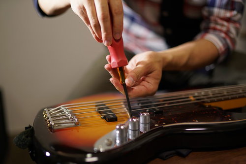 エレキベースのジャック部分をドライバーで外す