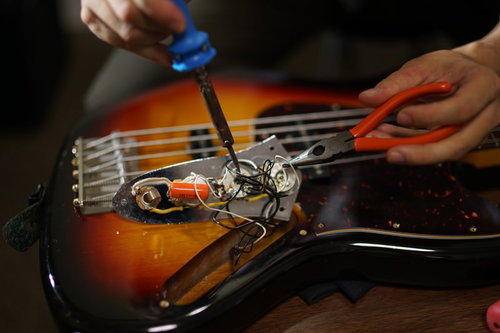 半田コテを使ってベースの配線を改造する作業