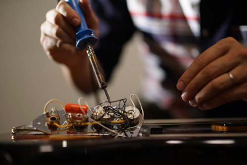 ベースの配線を半田コテを使ってメンテする様子