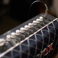 ギターアンプの複数のダイヤル式ツマミ部分の写真