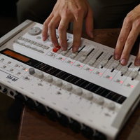 オーディオインターフェースのつまみとボタンを操作する手元の写真