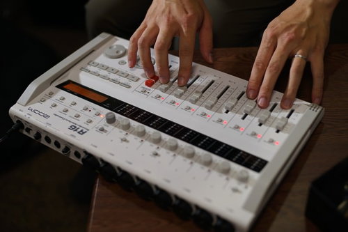 オーディオインターフェースのつまみとボタンを操作する手元