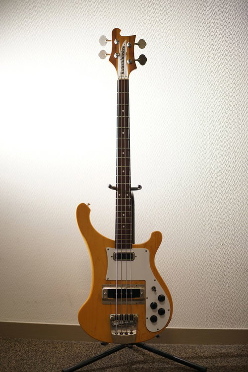 リッケンバッカーのベースギター、白い壁を背景にスタンドに立てかけた楽器