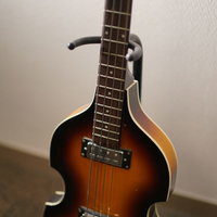 スタンドに立てかけたエレキベースと楽器機材の写真