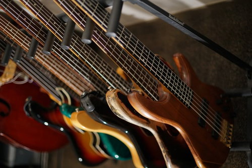 楽器スタンドに並べたベースギターの写真