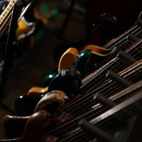 スタジオに立てかけられた複数のエレキベースの写真