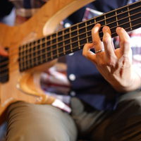 5弦ベースを弾くベーシストの左手フォームと指の押弦位置の写真