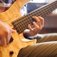 軽やかに指で弾くベースの手元、フィンガリングの技法の写真