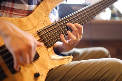 軽やかに指で弾くベースの手元、フィンガリングの技法