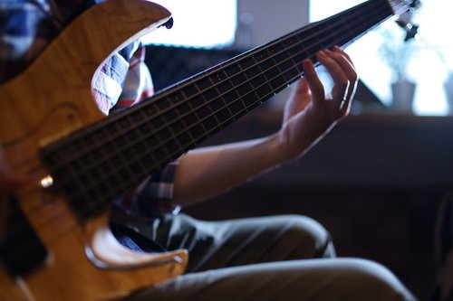 ベースを指弾きする左手の演奏風景とフレットボード