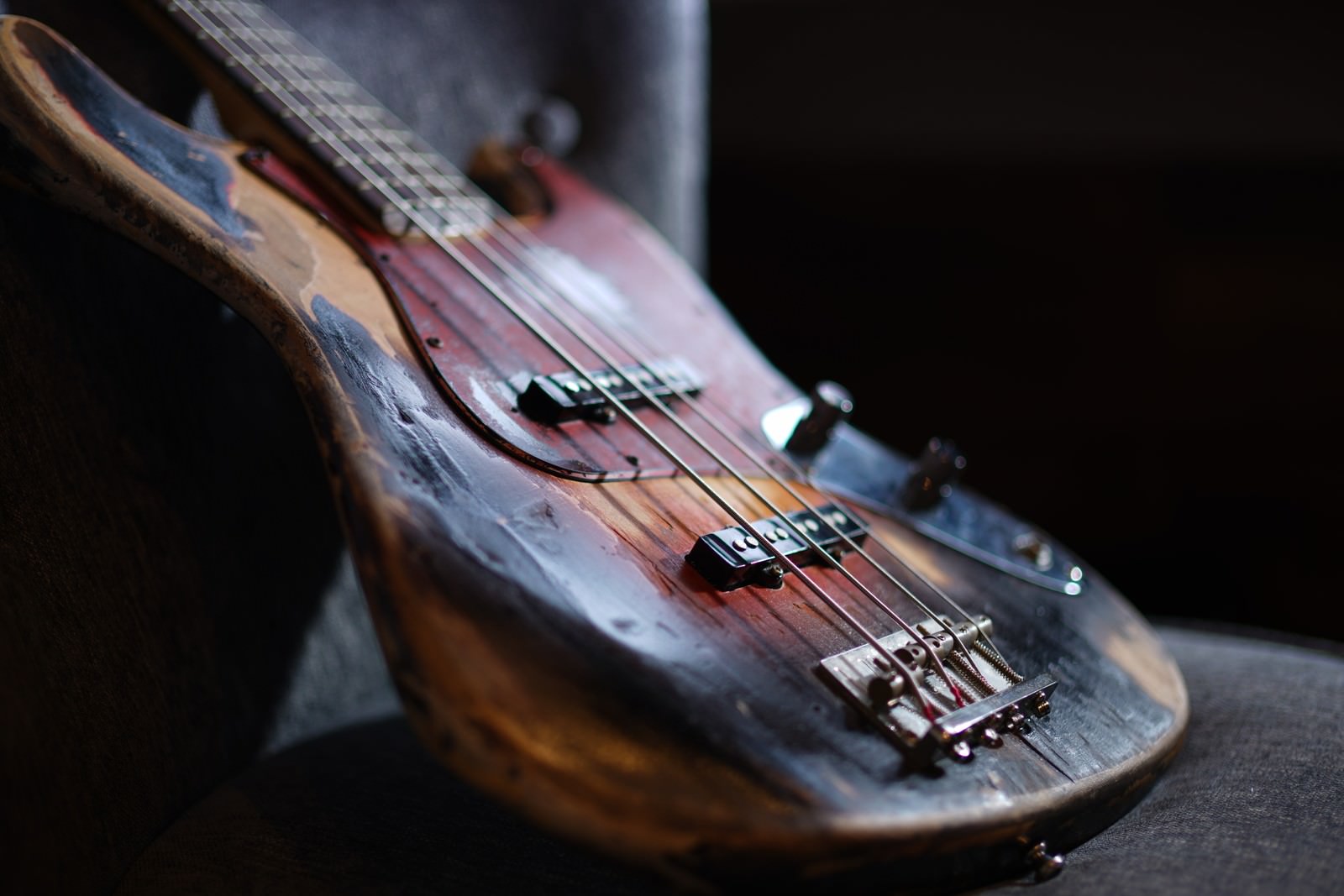 木目調のボディを持つ年季の入ったエレキベースのクローズアップ