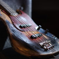 年季の入ったデザインのエレキベース、深い木目調のボディが魅力的の写真