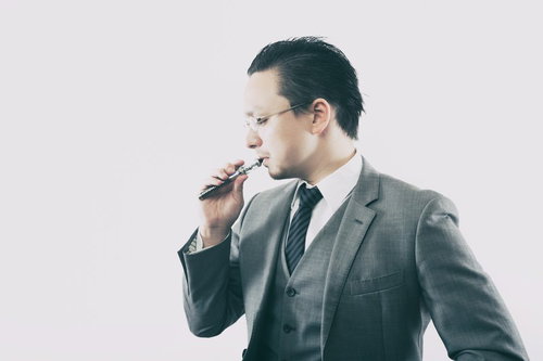 フレーバーを楽しむビジネスマンの電子タバコ