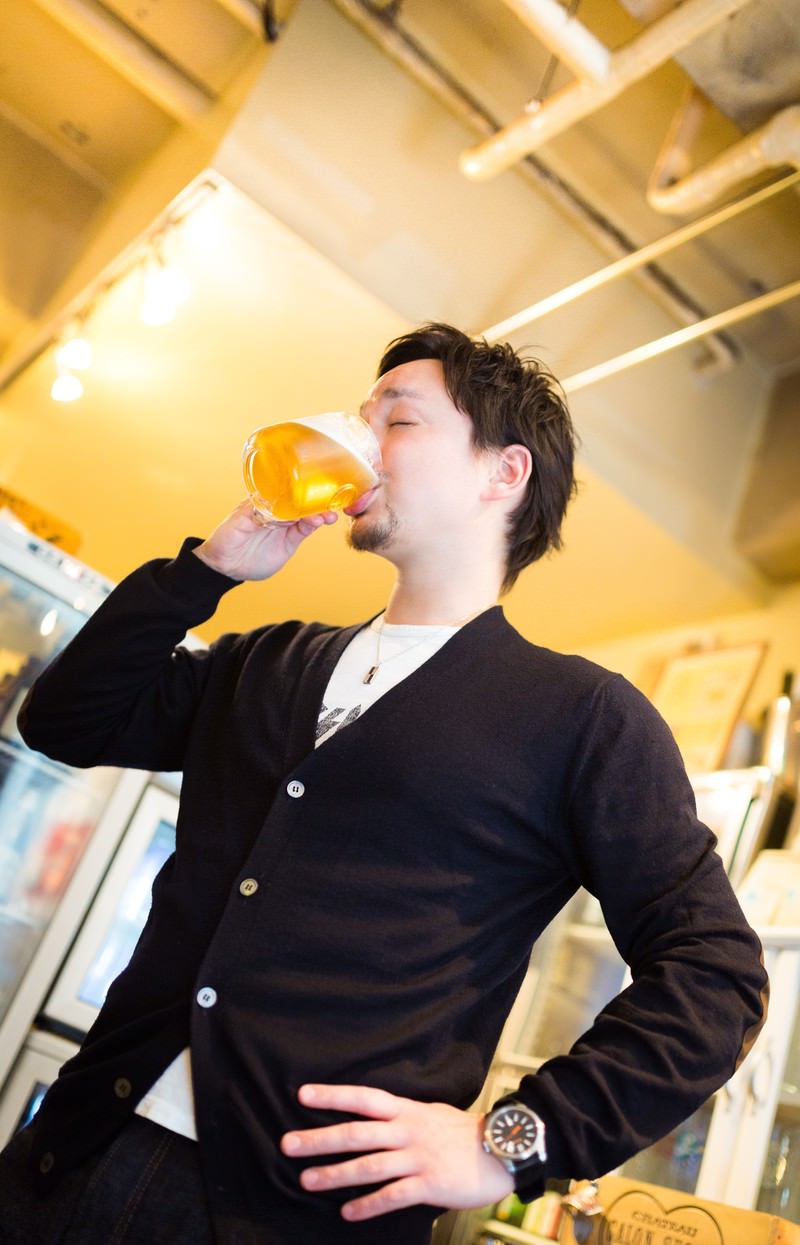 グラスを傾けてビールを飲む男性［モデル：Max_Ezaki］