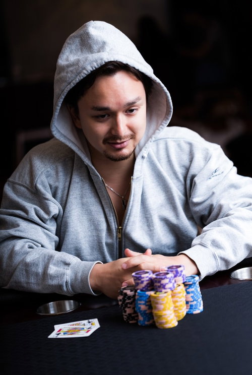 これが最後の大勝負、カジノのテーブルでチップに手をかけるギャンブラー