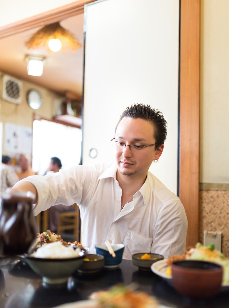 定食屋で丼を食べるドイツ人ハーフ男性［モデル：Max_Ezaki］