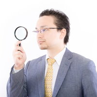 虫眼鏡で検索・アクセス解析をしているサラリーマンの写真