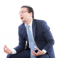 残念がるスーツ姿のビジネスマンの写真