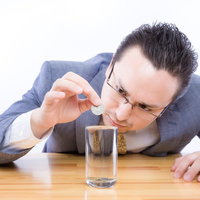 表面張力の効果を確かめる外資系サラリーマンの写真