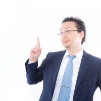 右手の人差し指を上に向けて閃いた外資系サラリーマンの写真