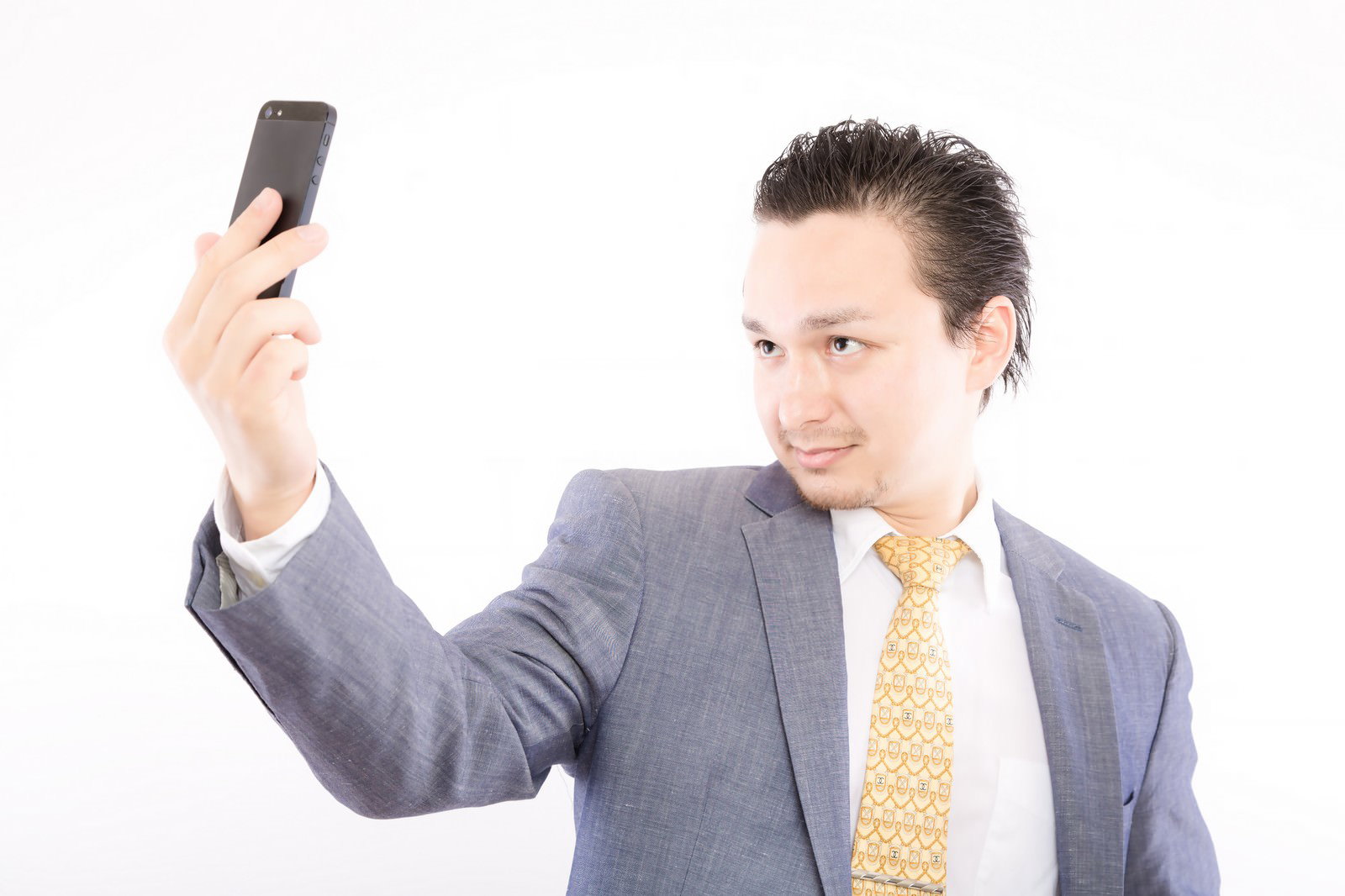 Suited man checking his hairline with a smartphone