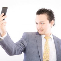 生え際のチェックに余念がないサラリーマンの写真