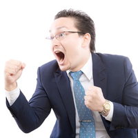 ガッツポーズで喜ぶスーツ姿の外国人男性の写真