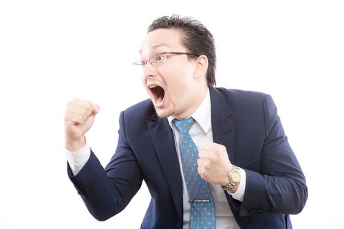 ガッツポーズで喜ぶスーツ姿の外国人男性