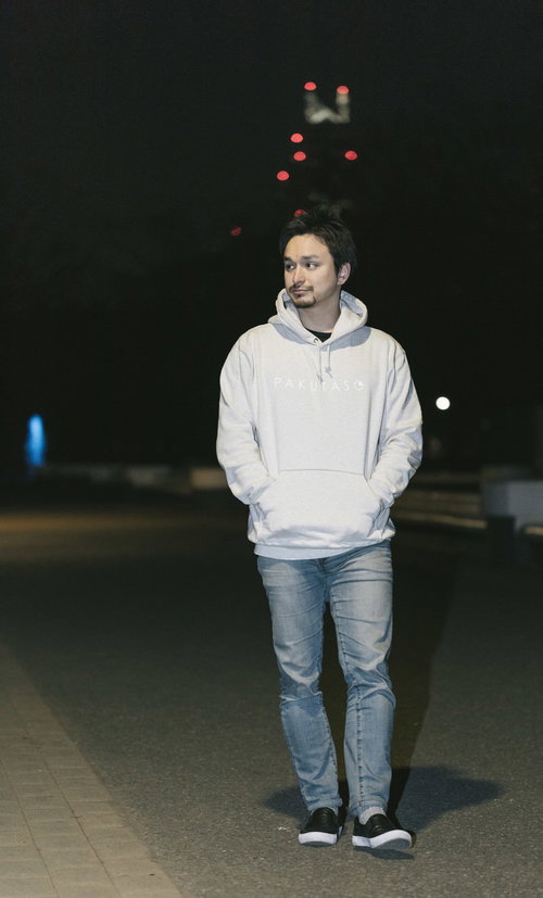 白いパーカーを着て夜の街を散歩するドイツ人ハーフの男性