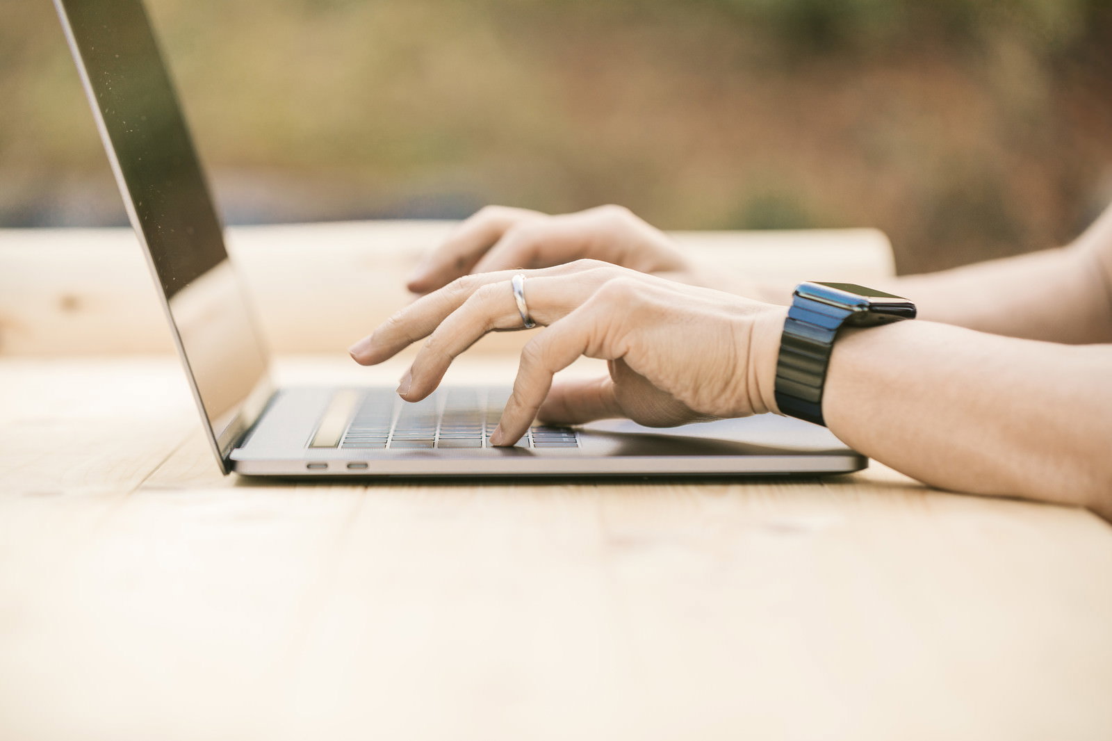 MacBookのキーボードを打つ手元のクローズアップ