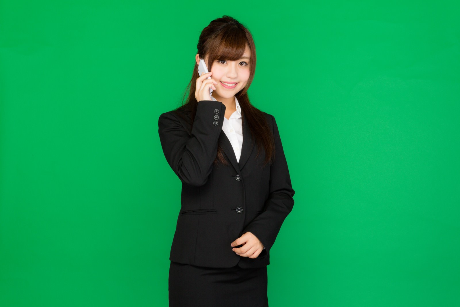 携帯電話に出る黒スーツの女性秘書（グリーンバック）［モデル：河村友歌］