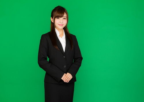企業の受付嬢がほほえむグリーンバック写真