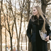 冬の公園で雑誌を持つブロンド美女の屋外ポートレートの写真