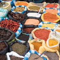 エクアドルの調味料屋で並ぶ色とりどりのスパイスと香辛料の写真