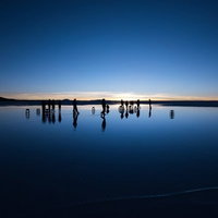 ウユニ塩湖の日の出を待つ人たち、鏡面水に映るシルエットの写真