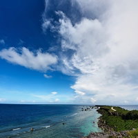 平安名埼灯台へと続く道と入道雲の写真